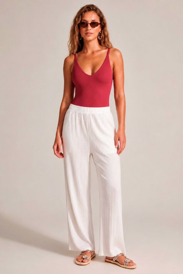 Look de verano bañador compressive rojo con pantalón blanco