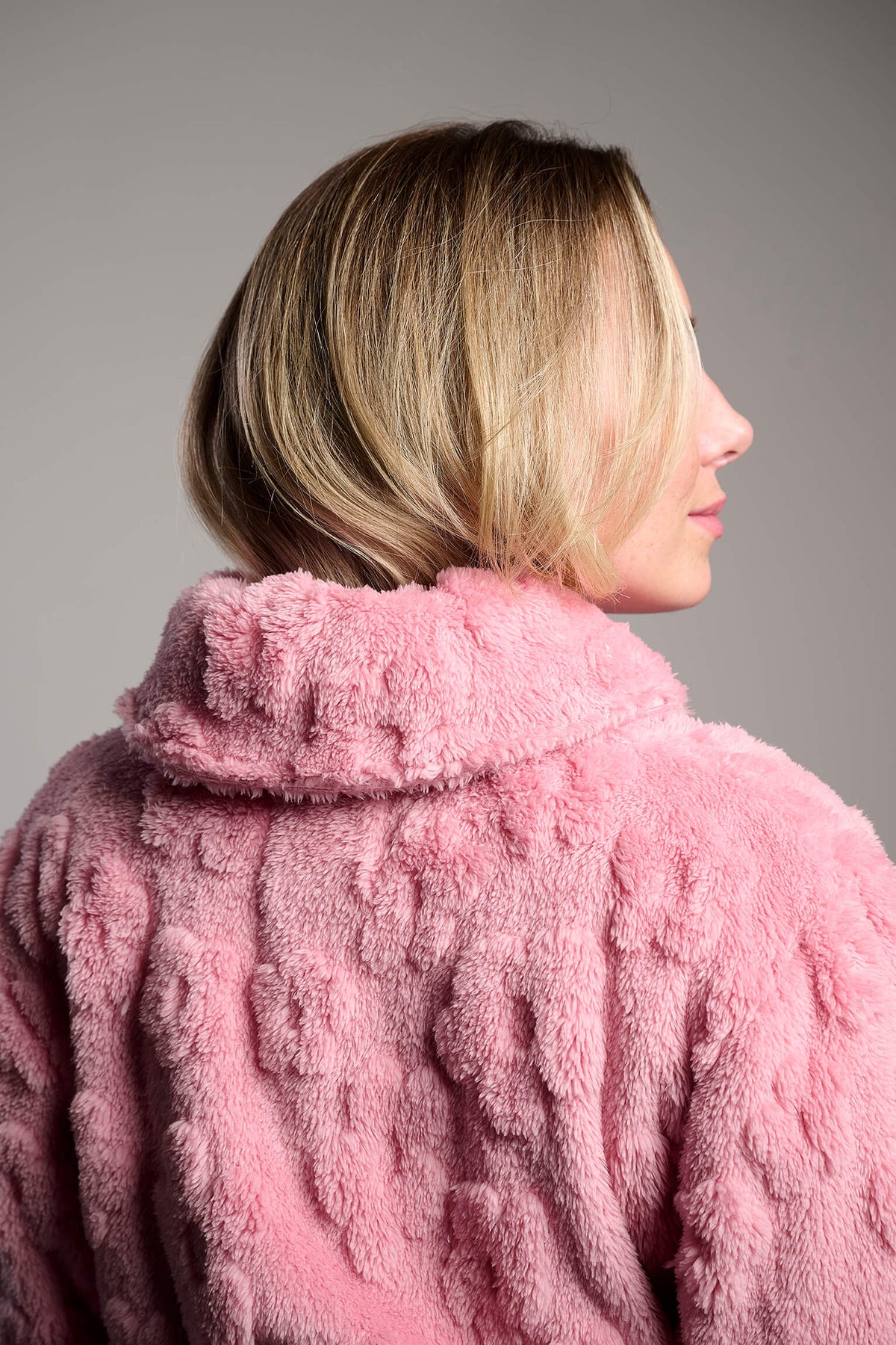 Bata corta de coralina polar rosa texturizada para mujer, diseño suave y cómodo para los meses fríos.