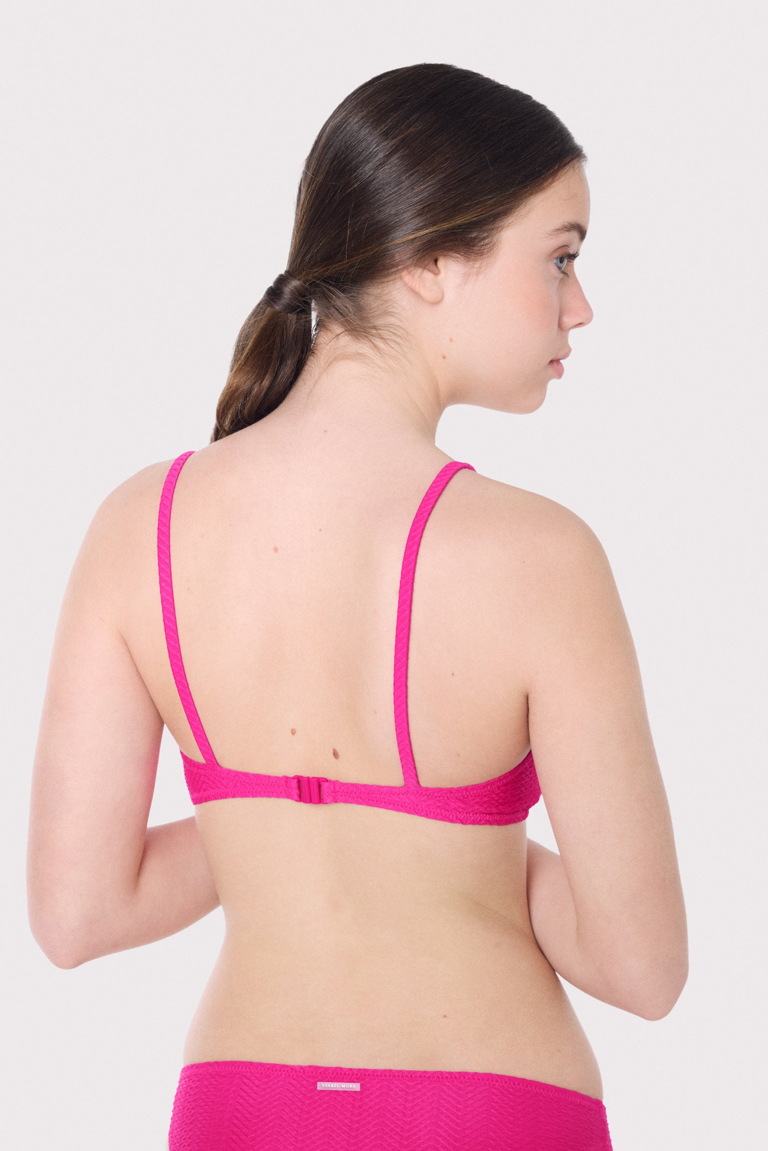 Top bikini juvenil texturizado detalles lazos fucsia
