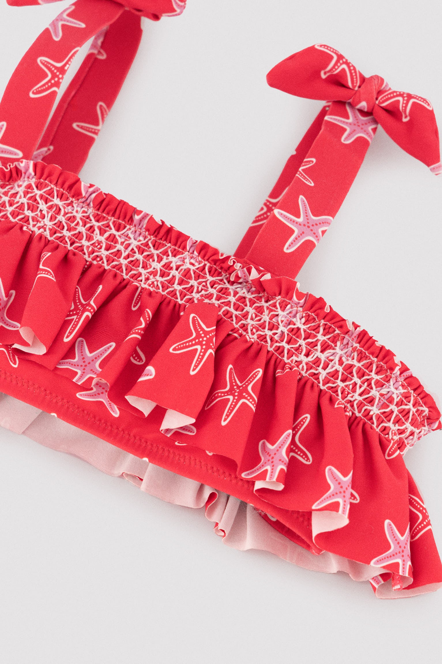 Bikini niña detalles volantes y nido de abeja estampado estrellas marinas