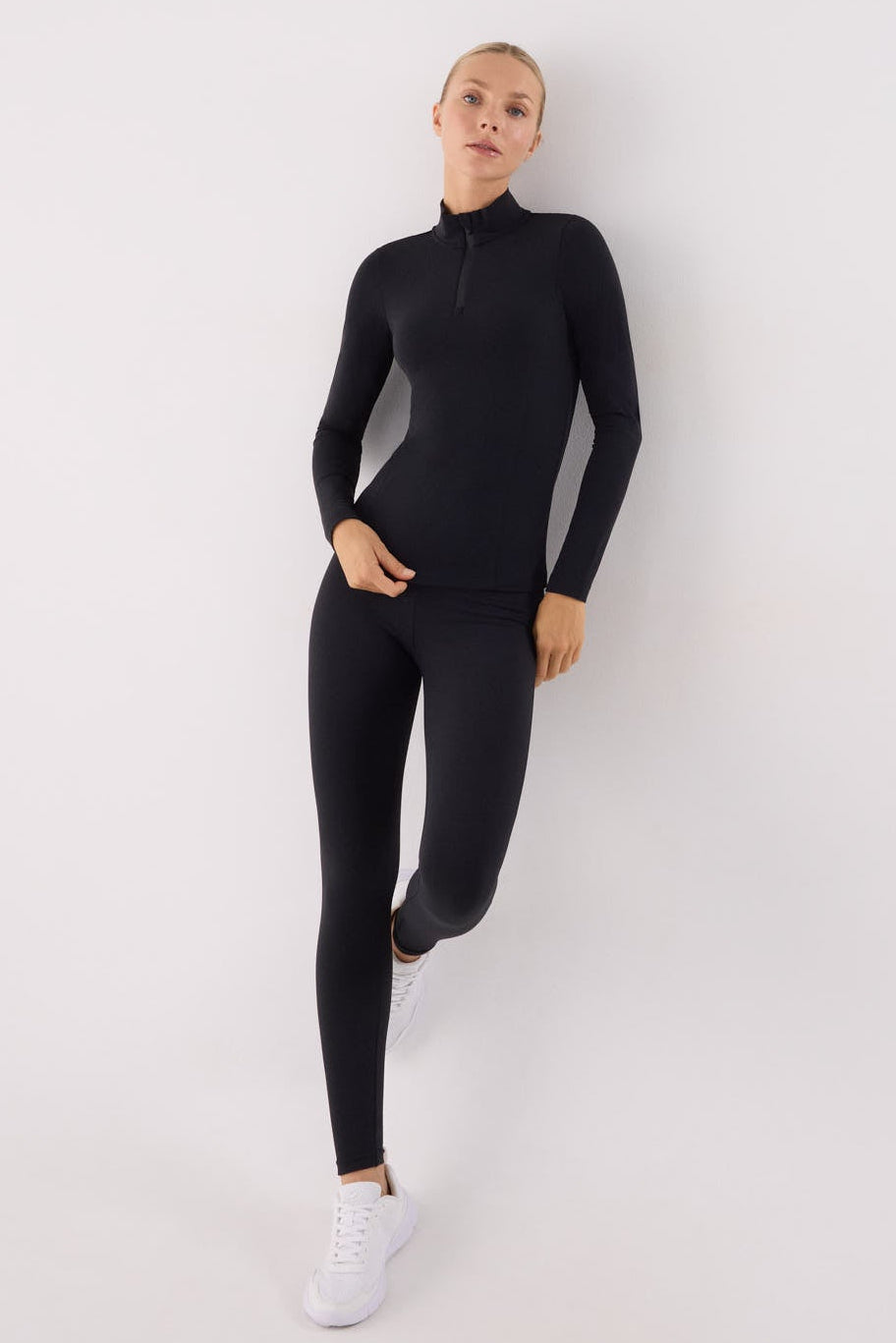 camiseta deportiva manga larga con media cremallera gimnasio en negro vista lateral del conjunto fitness tejido transpirable con interior afelpado
