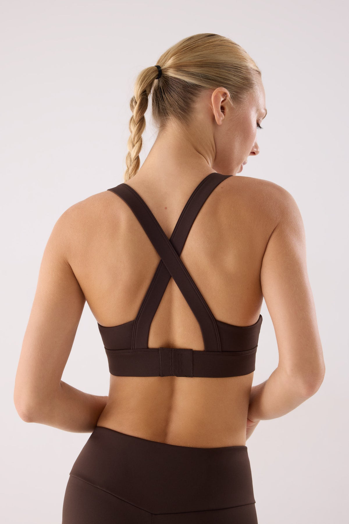 sujetador deportivo gimnasio sujeción media gimnasio en marrón dark chocolate vista en movimiento para entrenamientos copa fija transpirable broche multiposición