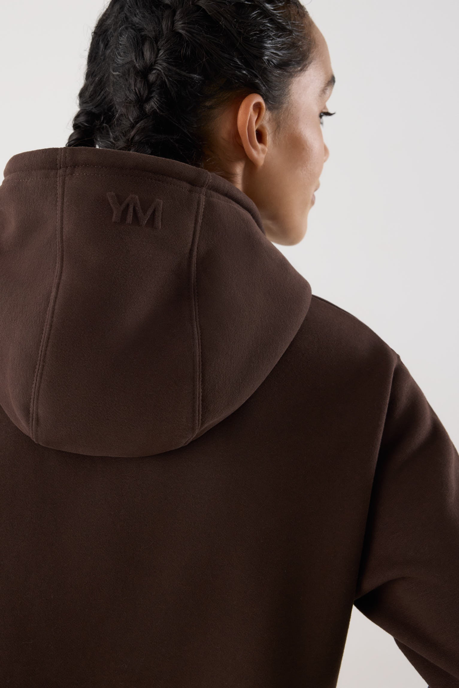 sudadera deportiva con capucha Slowloom en marrón dark chocolate vista lateral del conjunto fitness estilo relajado para looks comfy