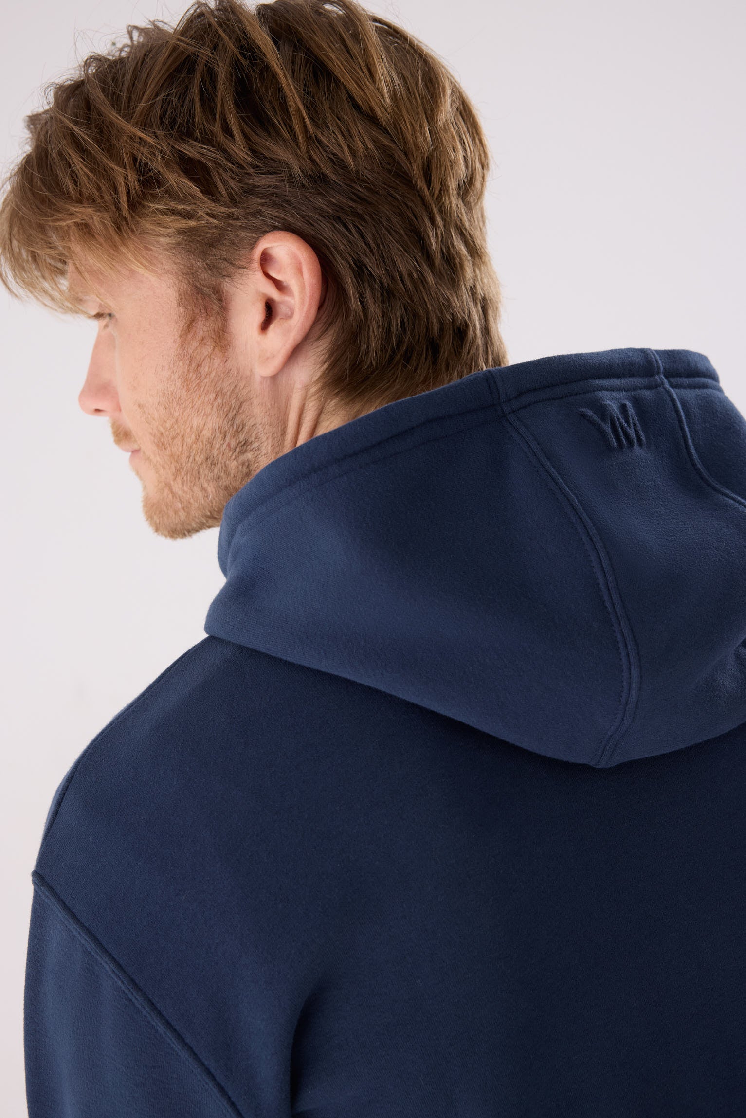 sudadera deportiva con capucha para hombre Slowloom en deep navy vista lateral del conjunto fitness silueta cómoda estilo casual