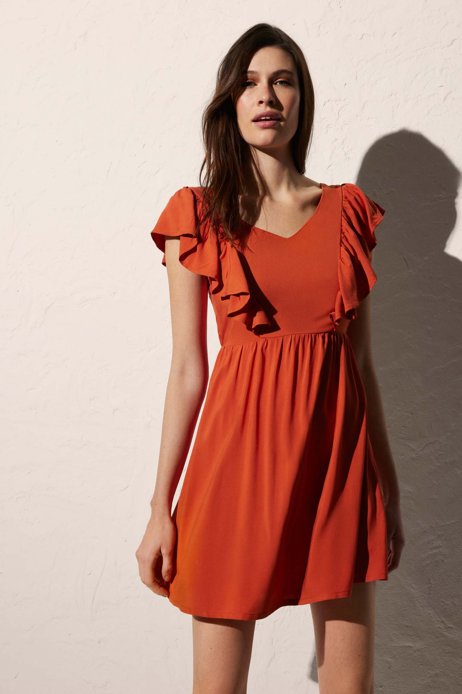 Short beach dress with bow detail on the orange back