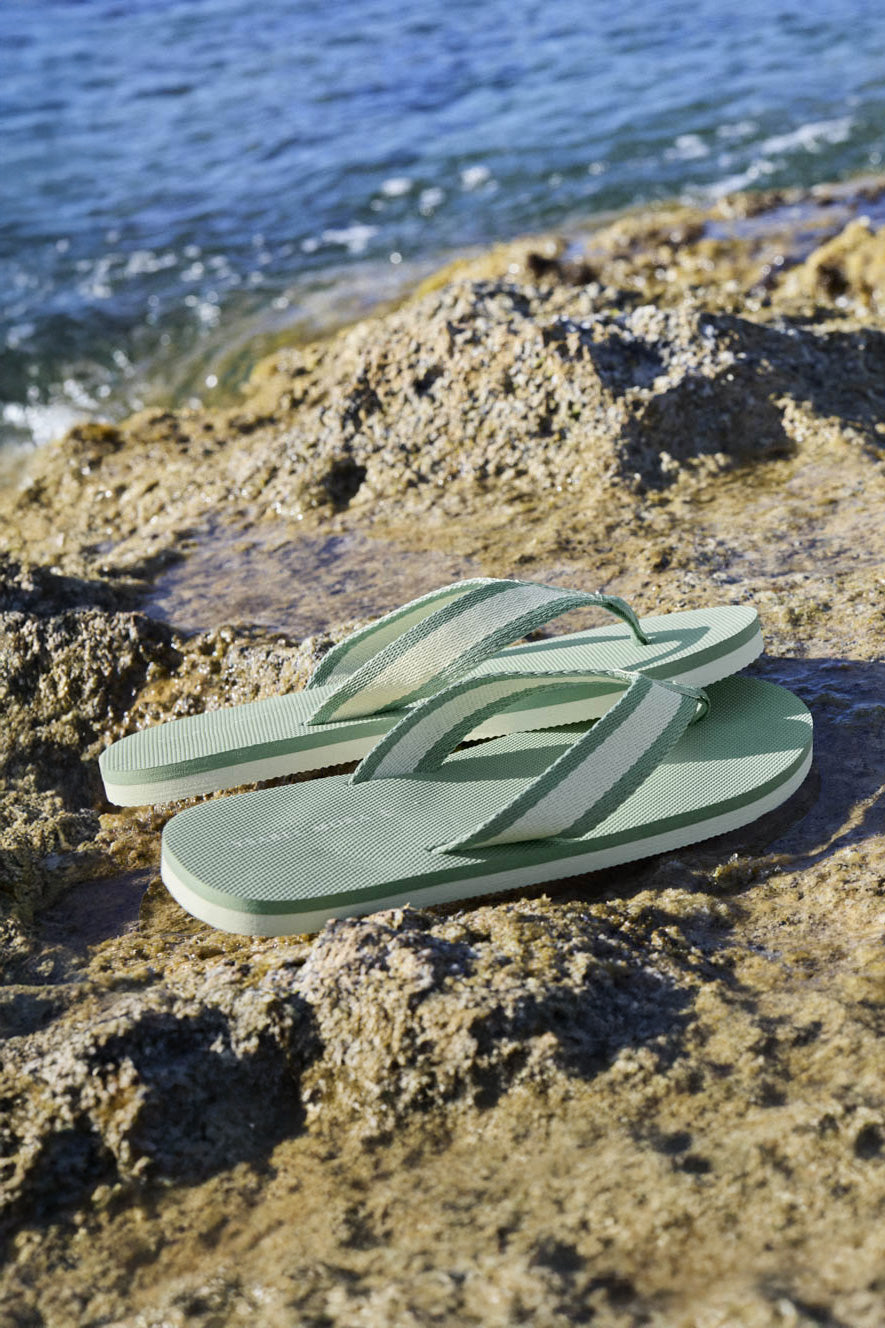Flip flops with green fabric strips