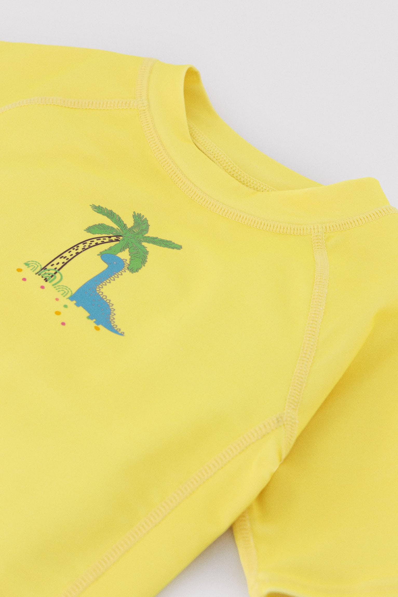 Camiseta de baño bebé dibujo dinosaurio y palmera